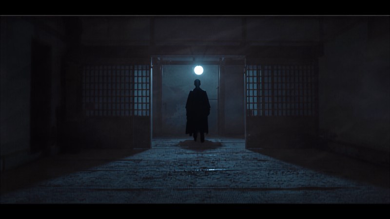 暗い和室に立つ人影